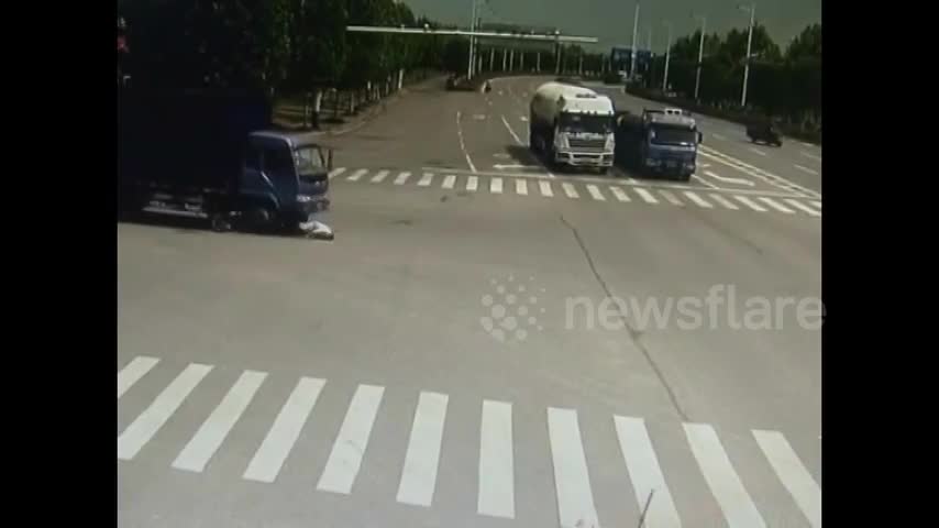 Video - Clip: Vượt đèn đỏ, người đàn ông thoát chết khó tin dưới gầm xe tải