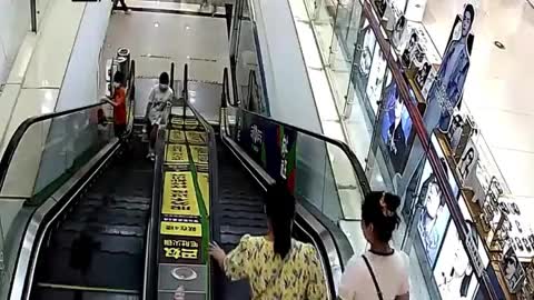Video - Clip: Nghịch ngợm, cậu bé bị mắc kẹt đầu khi đi thang cuốn
