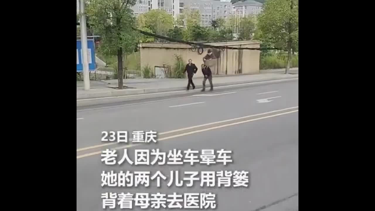 Video - Mẹ bị say xe, hai anh em thay nhau địu mẹ già đến bệnh viện