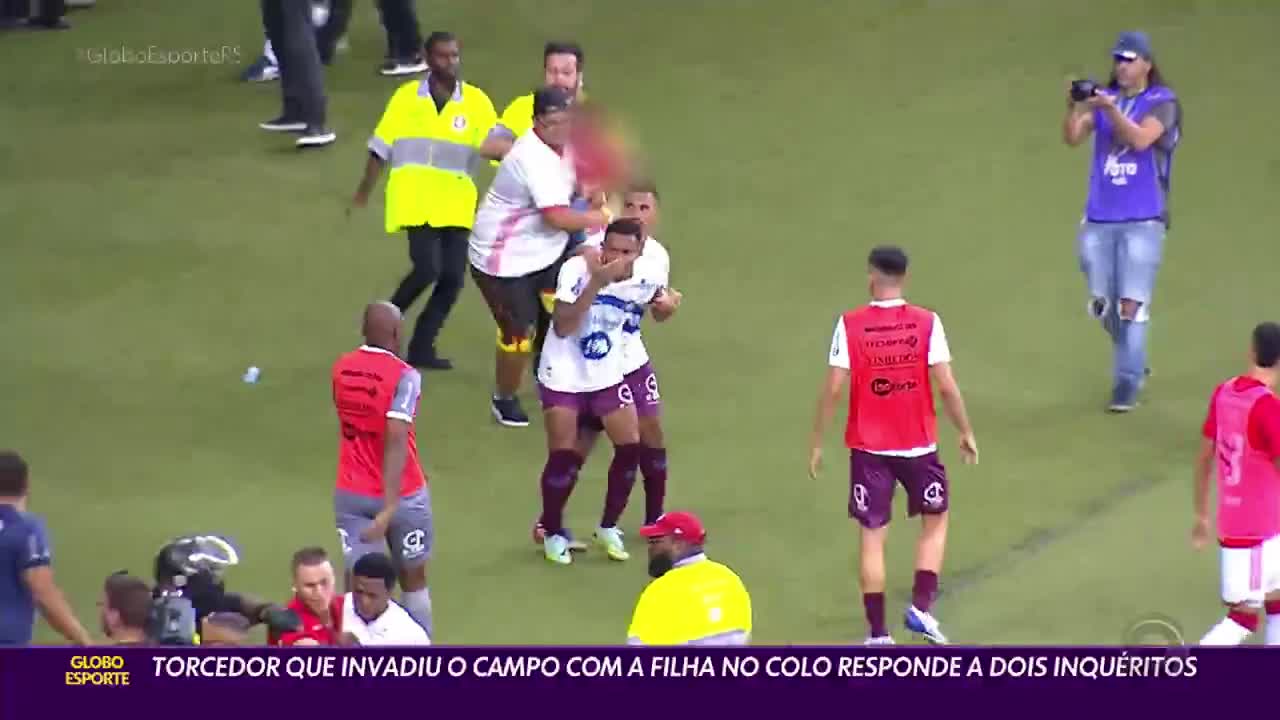 Video - Clip: Người đàn ông bế con gái lao xuống đánh cầu thủ trên sân