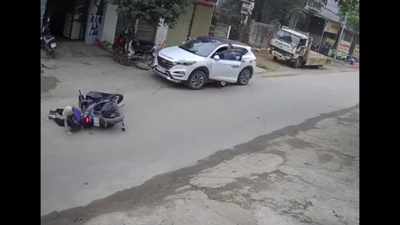 Video - Clip: Mở cửa bất cẩn, tài xế ô tô 'hạ gục' người phụ nữ đi xe máy