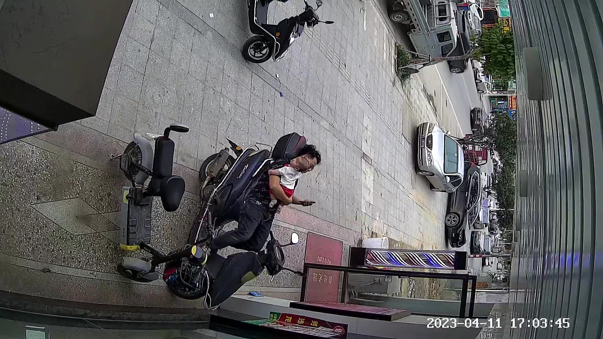 Video - Clip: Bế con nằm trên xe máy, hai bố con ngã xuống đất