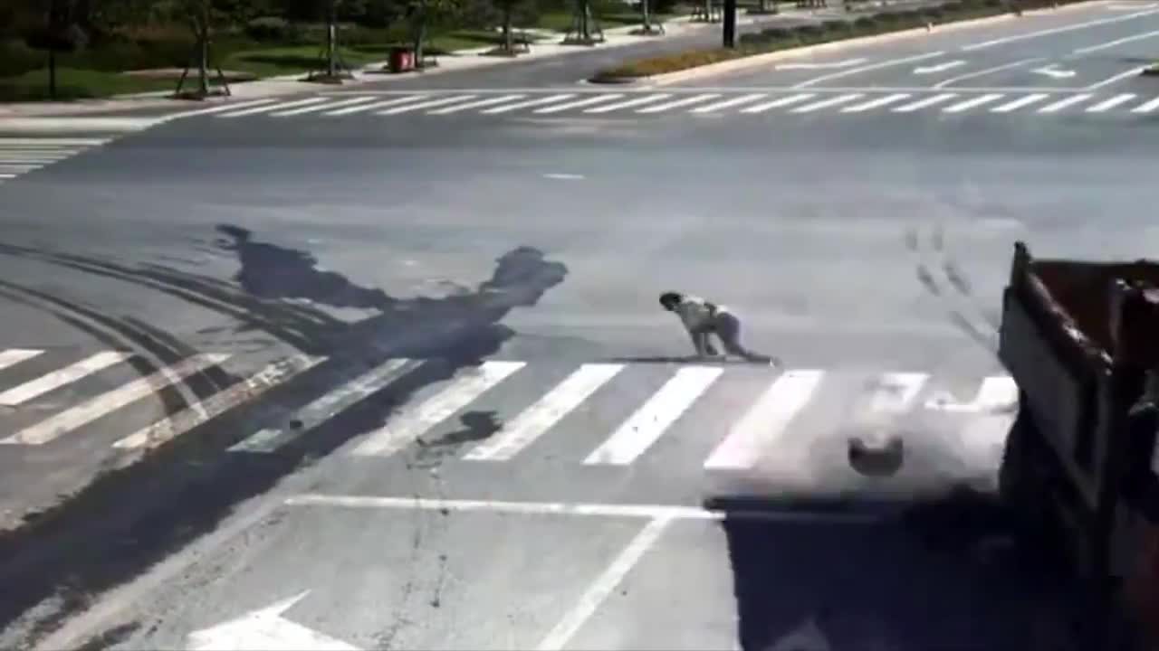 Video - Clip: Trượt ngã, nam thanh niên suýt bị xe tải cán trúng ngay ngã tư