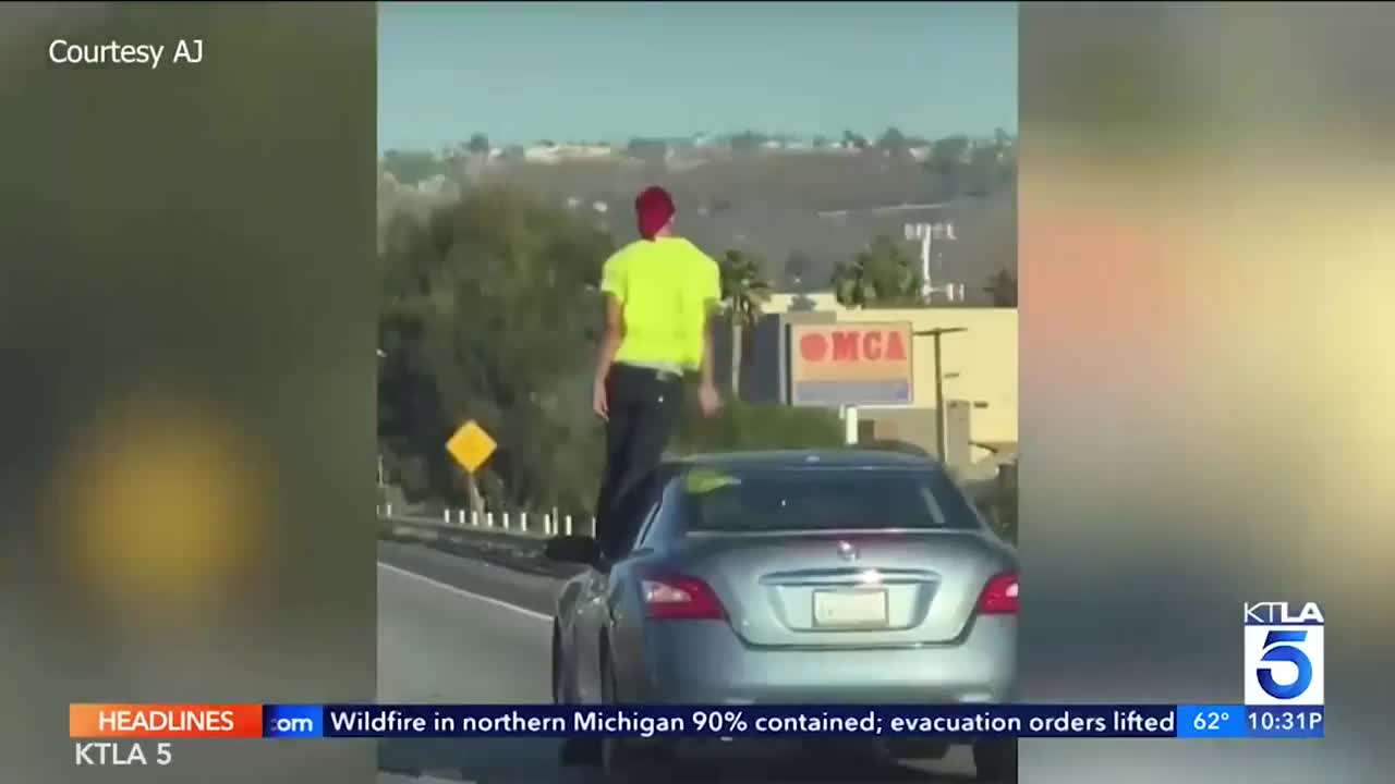 Video - Clip: Người đàn ông đứng trên cửa chiếc xe đang chạy gây sợ hãi