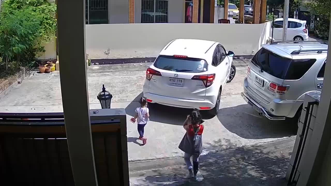 Video - Clip: Lùi ô tô, bố suýt tông trúng con gái đang ngồi giữa sân