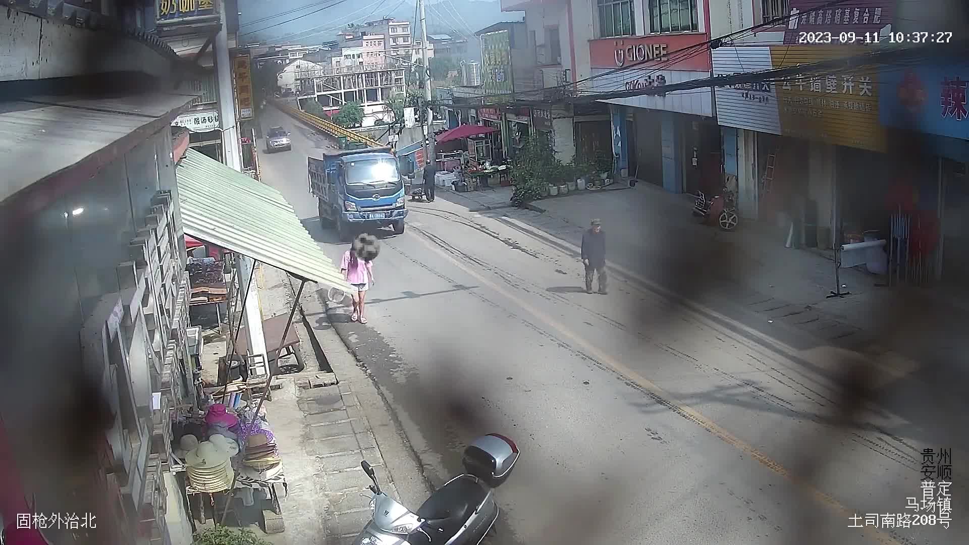 Video - Clip: Cửa thùng xe tải bất ngờ bật mở, đập trúng người phụ nữ đi bộ