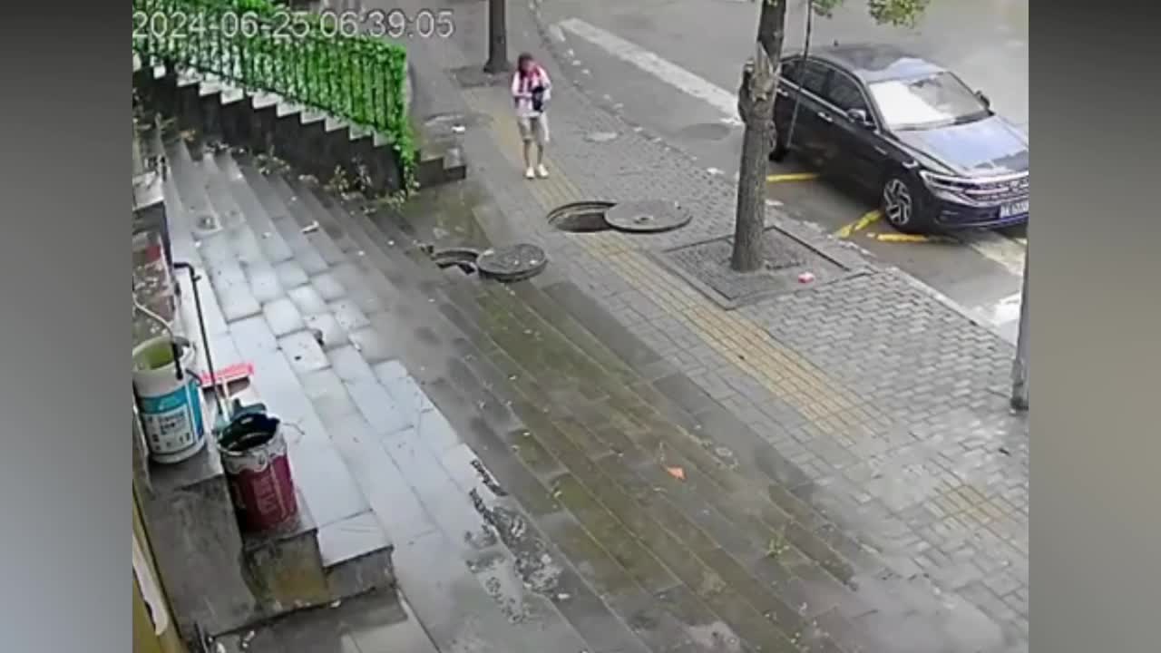 Video - Clip: Không nhìn đường, bé gái rơi xuống hố ga đang mở nắp