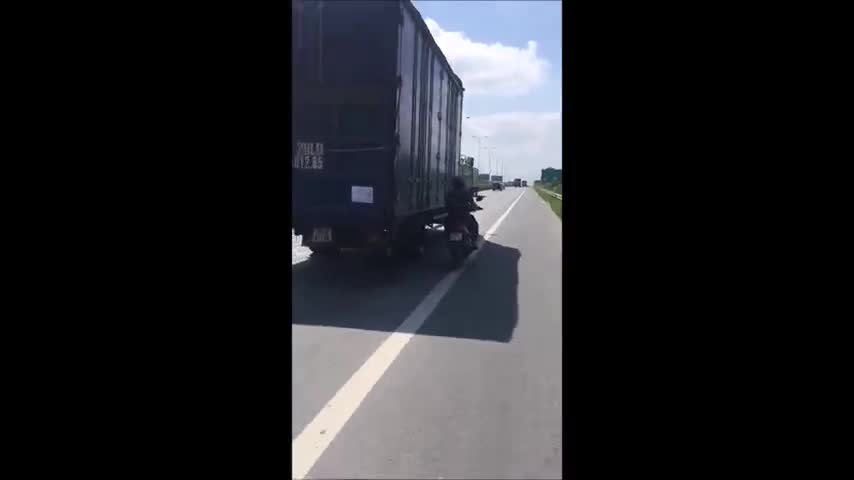 Clip: Người đàn ông liều mạng chạy song song xe tải để tránh nắng