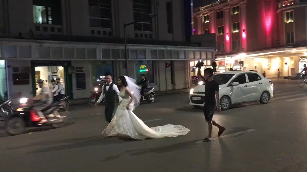 Cô dâu chú rể chạy giữa phố đông người để chụp ảnh cưới