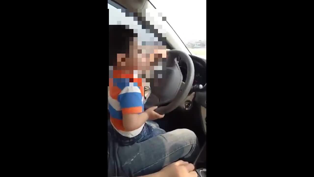  Bố mẹ cho bé trai 3 tuổi điều khiển xe ô tô trên đường