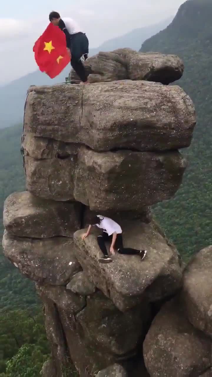  Clip: Đôi nam nữ liều mạng trèo lên mỏm đá chênh vênh để chụp ảnh