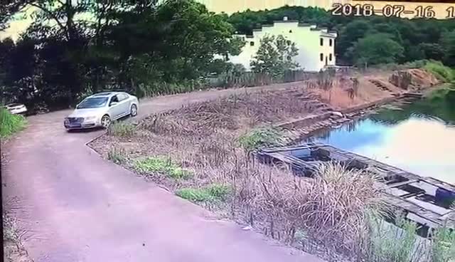Lùi xe bất cẩn, ô tô lao thẳng xuống hồ.
