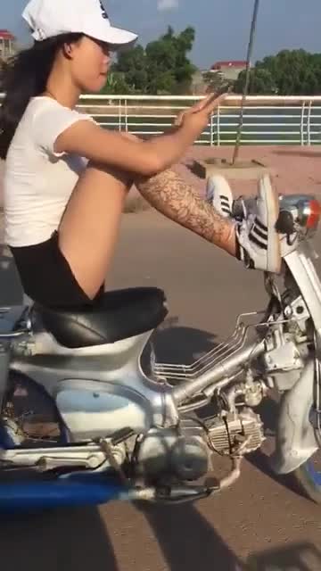 Thiếu nữ thản nhiên dùng chân lái xe máy