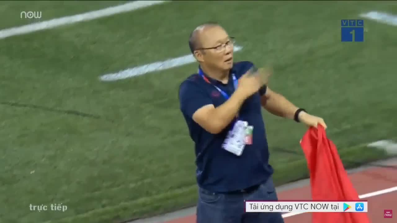 HLV Park Hang-seo đặt tay lên tim, giơ cao lá cờ Việt Nam để ăn mừng chức vô địch