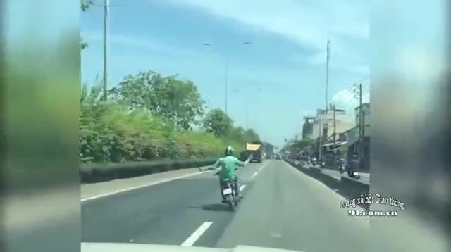 Thanh niên vừa đi xe máy vừa buông hai tay làm xiếc trên đường
