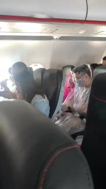 Video: Hai hành khách mặc nguyên bộ áo mưa trong suốt chuyến bay vì sợ dịch Covid-19