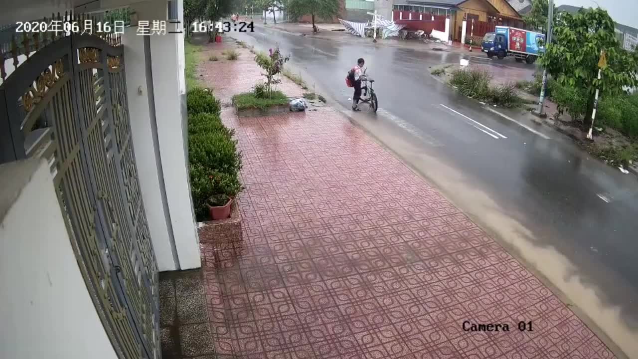 Cậu bé dắt xe đi bộ trong mưa và hành động bất ngờ khiến dân mạng chia sẻ rần rần