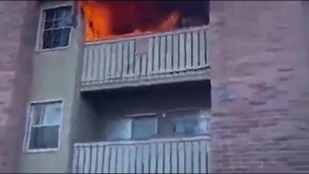 Người đàn ông đưa tay đỡ bé trai rơi từ tầng 3 của căn nhà đang bốc cháy